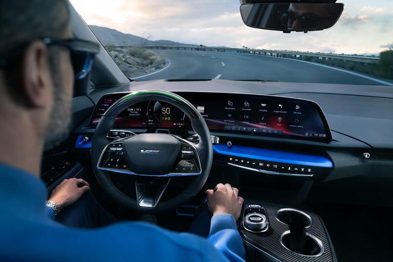 Front View of the 2026 OPTIQ-V Driving Through the Dusk Utilizing its Headlights | Penske Cadillac of South Bay in Torrance CA
