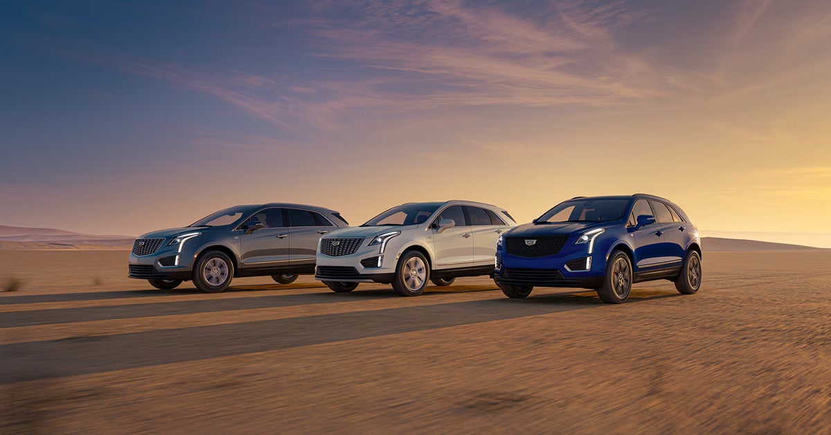 2026 Cadillac XT5 - Three models parked side by side in a desert open field